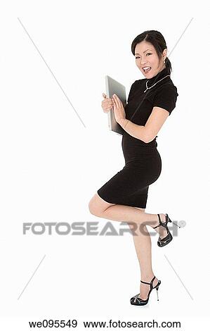 Beautiful Asian businesswoman holding a laptop computer View Large Photo Image Stock Photo - Beautiful Asian businesswoman holding a laptop computer. Fotosearch