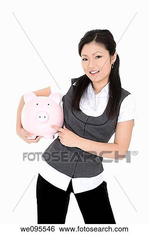 Beautiful Asian businesswoman holding a piggy bank View Large Photo Image Stock Photograph - Beautiful Asian businesswoman holding a piggy bank. Fotosearch
