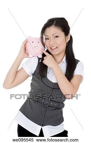 Beautiful Asian businesswoman holding a piggy bank View Large Photo Image Stock Photography - Beautiful Asian businesswoman holding a piggy bank. Fotosearch
