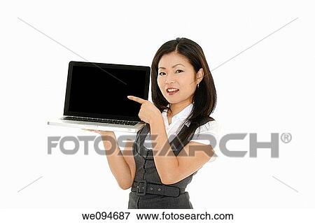 Beautiful Asian businesswoman holding and pointing at a laptop computer View Large Photo Image Stock Photo - Beautiful Asian businesswoman holding and pointing at a laptop computer. Fotosearch