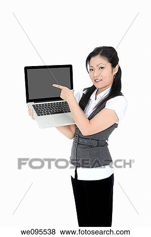 Beautiful Asian businesswoman holding and pointing at a laptop computer View Large Photo Image Stock Photo - Beautiful Asian businesswoman holding and pointing at a laptop computer. Fotosearch