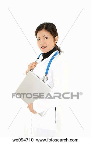 Beautiful Asian doctor or nurse holding a laptop computer View Large Photo Image Stock Image - Beautiful Asian doctor or nurse holding a laptop computer. Fotosearch