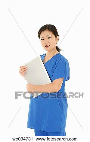 Stock Image - Beautiful Asian doctor or nurse holding a laptop computer. Fotosearch