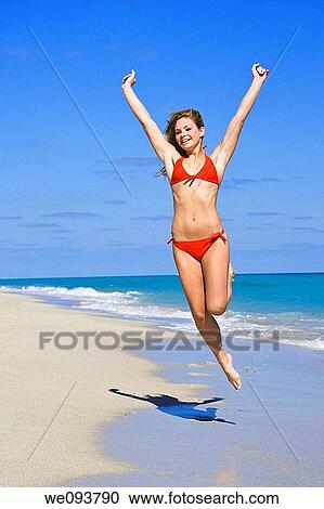 Beautiful Caucasian female teenage having fun on South Beach jumping into the air wearing a swimsuit View Large Photo Image Stock Image - Beautiful Caucasian female teenage having fun on South Beach jumping into the air wearing a swimsuit. Fotosearch