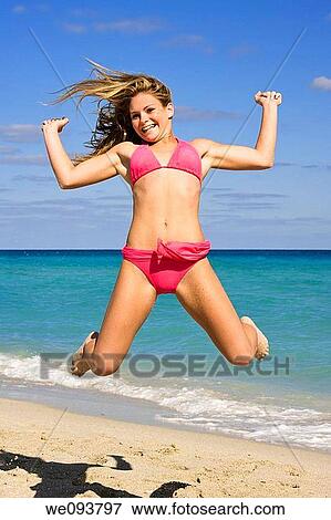 Beautiful Caucasian female teenage having fun on South Beach jumping into the air wearing a swimsuit View Large Photo Image Stock Photo - Beautiful Caucasian female teenage having fun on South Beach jumping into the air wearing a swimsuit. Fotosearch