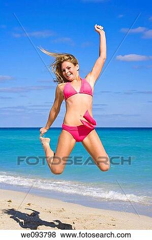Beautiful Caucasian female teenage having fun on South Beach jumping into the air wearing a swimsuit View Large Photo Image Stock Photo - Beautiful Caucasian female teenage having fun on South Beach jumping into the air wearing a swimsuit. Fotosearch