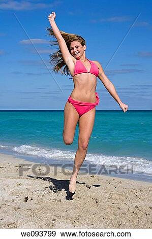 Beautiful Caucasian female teenage having fun on South Beach jumping into the air wearing a swimsuit View Large Photo Image Stock Photo - Beautiful Caucasian female teenage having fun on South Beach jumping into the air wearing a swimsuit. Fotosearch