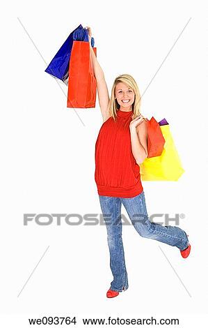 Beautiful Caucasian teen holding shopping bags while standing on a white background View Large Photo Image Picture - Beautiful Caucasian teen holding shopping bags while standing on a white background. Fotosearch