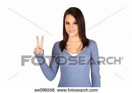 Stock Photograph - Beautiful Caucasian teenager counting on fingers on green background. Fotosearch