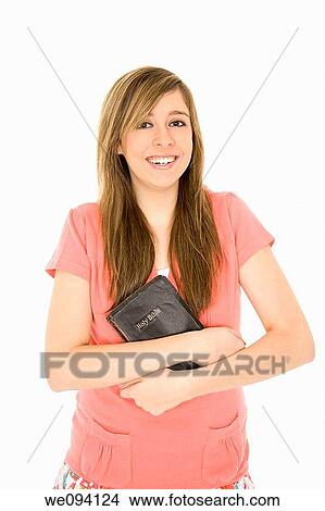 Beautiful caucasian teenager holding a bible on a white background View Large Photo Image Picture - Beautiful caucasian teenager holding a bible on a white background. Fotosearch