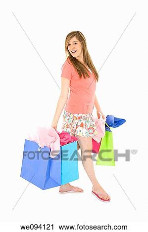 Beautiful Caucasian teenager holding shopping bags while standing on a white background View Large Photo Image Stock Image - Beautiful Caucasian teenager holding shopping bags while standing on a white background. Fotosearch