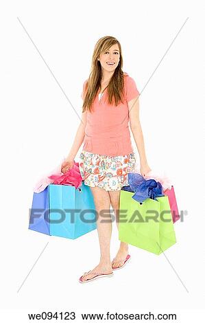 Beautiful Caucasian teenager holding shopping bags while standing on a white background View Large Photo Image Stock Image - Beautiful Caucasian teenager holding shopping bags while standing on a white background. Fotosearch