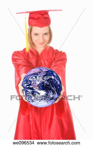 Beautiful Caucasian teenager in a graduation gown holding the world View Large Photo Image Picture - Beautiful Caucasian teenager in a graduation gown holding the world. Fotosearch