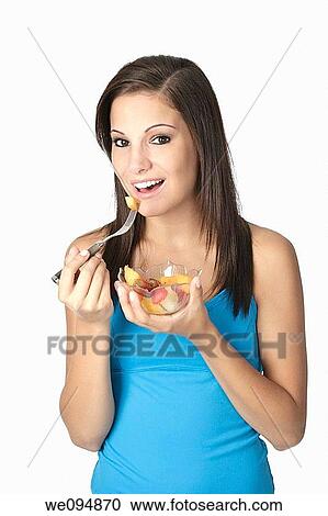 Beautiful Caucasian woman eating a bowl of mixed fruit on a white background View Large Photo Image Stock Image - Beautiful Caucasian woman eating a bowl of mixed fruit on a white background. Fotosearch