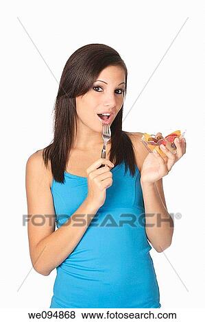 Beautiful Caucasian woman eating a bowl of mixed fruit on a white background View Large Photo Image Stock Photo - Beautiful Caucasian woman eating a bowl of mixed fruit on a white background. Fotosearch