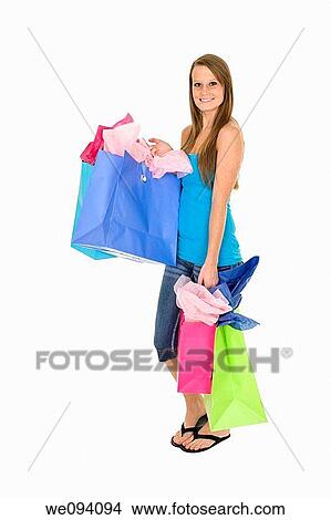 Beautiful Caucasian woman holding shopping bags while standing on a white background View Large Photo Image Picture - Beautiful Caucasian woman holding shopping bags while standing on a white background. Fotosearch