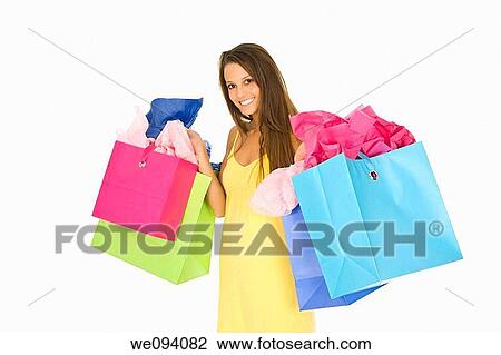 Beautiful Caucasian woman holding shopping bags while standing on a white background View Large Photo Image Stock Image - Beautiful Caucasian woman holding shopping bags while standing on a white background. Fotosearch
