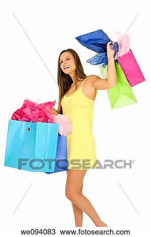 Beautiful Caucasian woman holding shopping bags while standing on a white background View Large Photo Image Stock Image - Beautiful Caucasian woman holding shopping bags while standing on a white background. Fotosearch