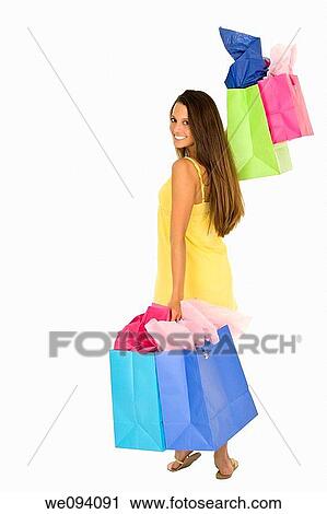 Beautiful Caucasian woman holding shopping bags while standing on a white background View Large Photo Image Stock Image - Beautiful Caucasian woman holding shopping bags while standing on a white background. Fotosearch