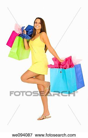 Beautiful Caucasian woman holding shopping bags while standing on a white background View Large Photo Image Stock Photo - Beautiful Caucasian woman holding shopping bags while standing on a white background. Fotosearch