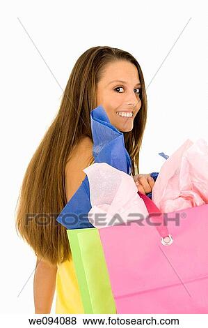 Beautiful Caucasian woman holding shopping bags while standing on a white background View Large Photo Image Stock Photo - Beautiful Caucasian woman holding shopping bags while standing on a white background. Fotosearch