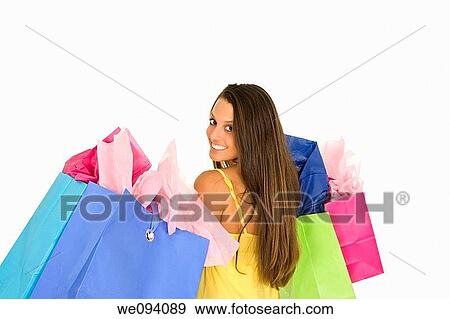 Beautiful Caucasian woman holding shopping bags while standing on a white background View Large Photo Image Stock Photo - Beautiful Caucasian woman holding shopping bags while standing on a white background. Fotosearch