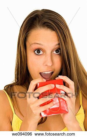 Stock Photograph - Beautiful Caucasian woman holding shopping bags while standing on a white background. Fotosearch