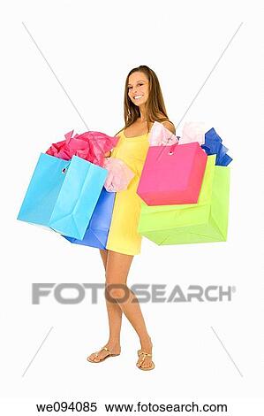 Beautiful Caucasian woman holding shopping bags while standing on a white background View Large Photo Image Stock Photography - Beautiful Caucasian woman holding shopping bags while standing on a white background. Fotosearch