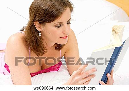 Beautiful Caucasian woman in bed reading a book View Large Photo Image Picture - Beautiful Caucasian woman in bed reading a book. Fotosearch