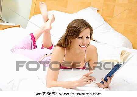 Beautiful Caucasian woman in bed reading a book View Large Photo Image Stock Image - Beautiful Caucasian woman in bed reading a book. Fotosearch