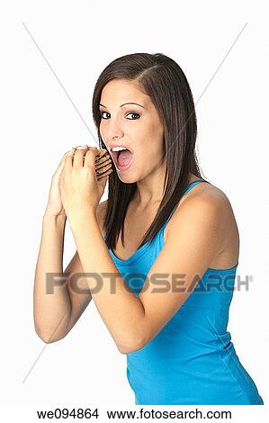 Beautiful Caucasian woman in her early 20s eating Chocolate Chip Cookies Concept of eating junk food View Large Photo Image Picture - Beautiful Caucasian woman in her early 20s eating Chocolate Chip Cookies Concept of eating junk food. Fotosearch