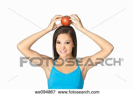 Beautiful Caucasian woman in her early 20s with an apple on top of her head Concept of eating healthy food View Large Photo Image Stock Photo - Beautiful Caucasian woman in her early 20s with an apple on top of her head Concept of eating healthy food. Fotosearch