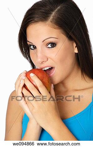 Stock Photograph - Beautiful Caucasian woman in her early 20s eating an apple Concept of eating healthy food. Fotosearch