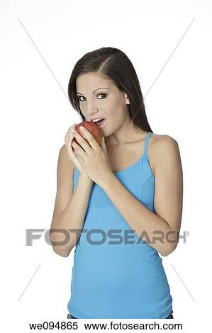 Stock Photography - Beautiful Caucasian woman in her early 20s eating Chocolate Chip Cookies Concept of eating junk food. Fotosearch