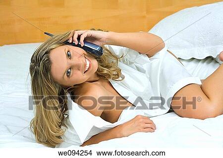 Beautiful caucasian woman laying in bed talking on the phone View Large Photo Image Picture - Beautiful caucasian woman laying in bed talking on the phone. Fotosearch