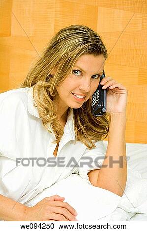 Beautiful caucasian woman setting in bed talking on the phone View Large Photo Image Stock Image - Beautiful caucasian woman setting in bed talking on the phone. Fotosearch
