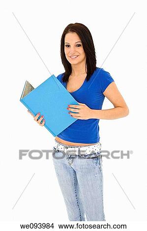 Beautiful caucasian woman standing on a white background wearing casaul clothing and smiling and holding a book View Large Photo Image Picture - Beautiful caucasian woman standing on a white background wearing casaul clothing and smiling and holding a book. Fotosearch