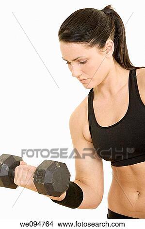 Picture - Beautiful Caucasian woman using dumbbells on white background. Fotosearch