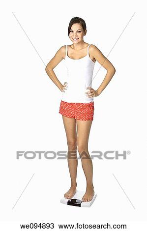 Beautiful Caucasian woman weighting herself and very excited about it View Large Photo Image Stock Image - Beautiful Caucasian woman weighting herself and very excited about it. Fotosearch