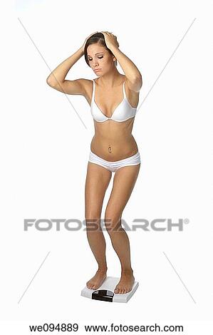 Beautiful Caucasian woman weighting herself and very upset about it View Large Photo Image Stock Photo - Beautiful Caucasian woman weighting herself and very upset about it. Fotosearch