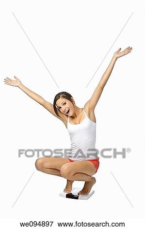 Beautiful Caucasian woman weighting herself and very excited about it View Large Photo Image Stock Photo - Beautiful Caucasian woman weighting herself and very excited about it. Fotosearch