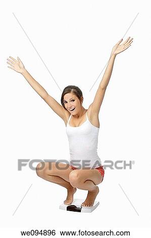 Beautiful Caucasian woman weighting herself and very excited about it View Large Photo Image Stock Photograph - Beautiful Caucasian woman weighting herself and very excited about it. Fotosearch