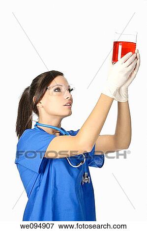 Beautiful Caucasian woman working as a laboratory technician studing a beaker of red liquid View Large Photo Image Stock Photo - Beautiful Caucasian woman working as a laboratory technician studing a beaker of red liquid. Fotosearch