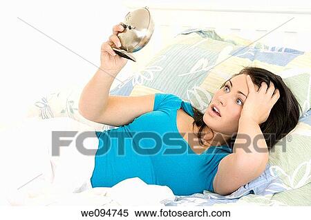 Stock Photography - Beautiful woman oversleeping in the morning. Fotosearch