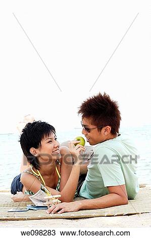 Beautiful young asian couple having fun with apple View Large Photo Image Stock Image - Beautiful young asian couple having fun with apple. Fotosearch