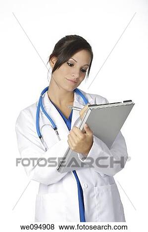 Stock Photo - Beautiful young doctor writing on the pad over white background. Fotosearch