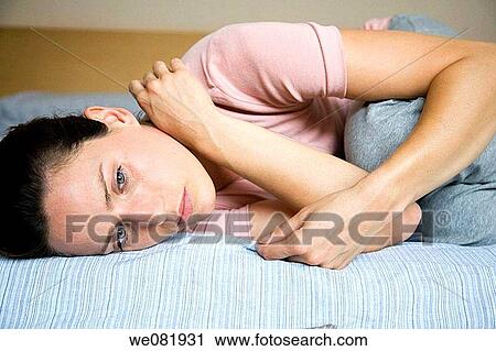 Stock Image - bed, brown hair, blue eyes, absorbed. Fotosearch
