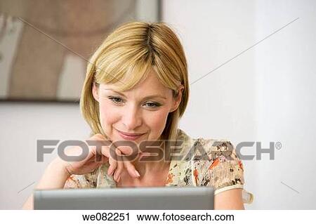 Stock Image - blond, computer, at-home. Fotosearch