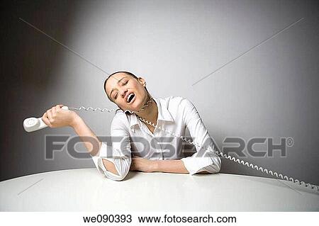 Stock Image - Bored Worker Office Woman playing with phone. Fotosearch