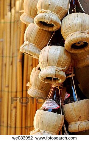Stock Image - Bottles of Chianti Montelonti Le Coste hanging in front of the local wine shop in Italy. Fotosearch
